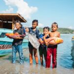 Keberlanjutan ekosistem laut di Pulau Obi memberikan manfaat nyata bagi gizi dan ekonomi masyarakat. Tampak anak-anak pesisir di Desa Soligi membawa ikan segar hasil tangkapan nelayan
